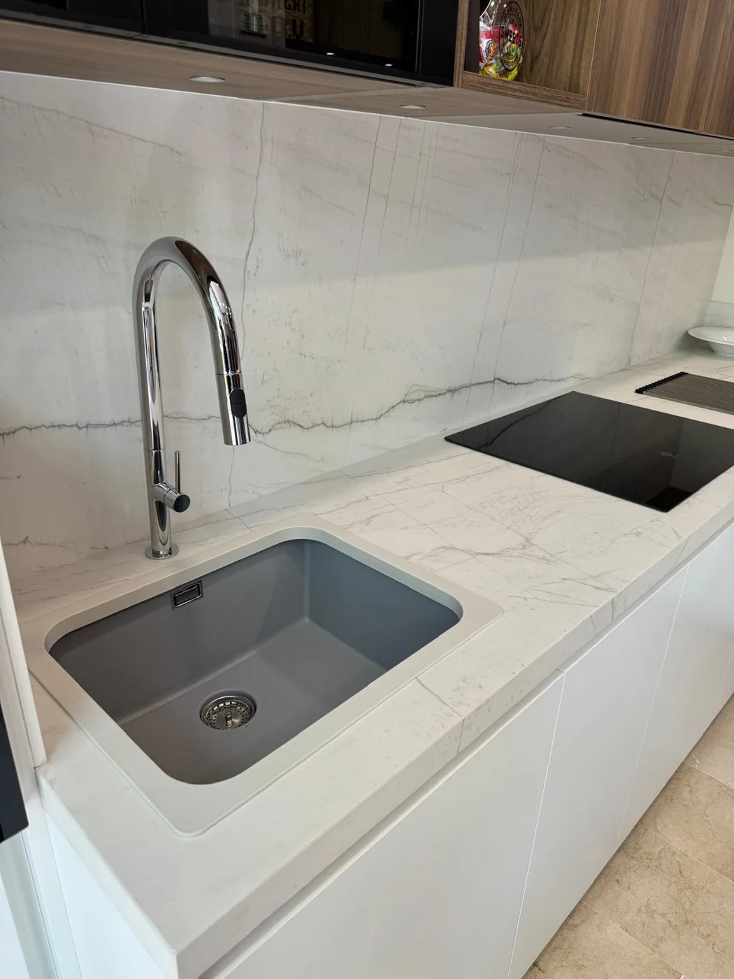 Cocina blanca con protector gris junto al fregadero